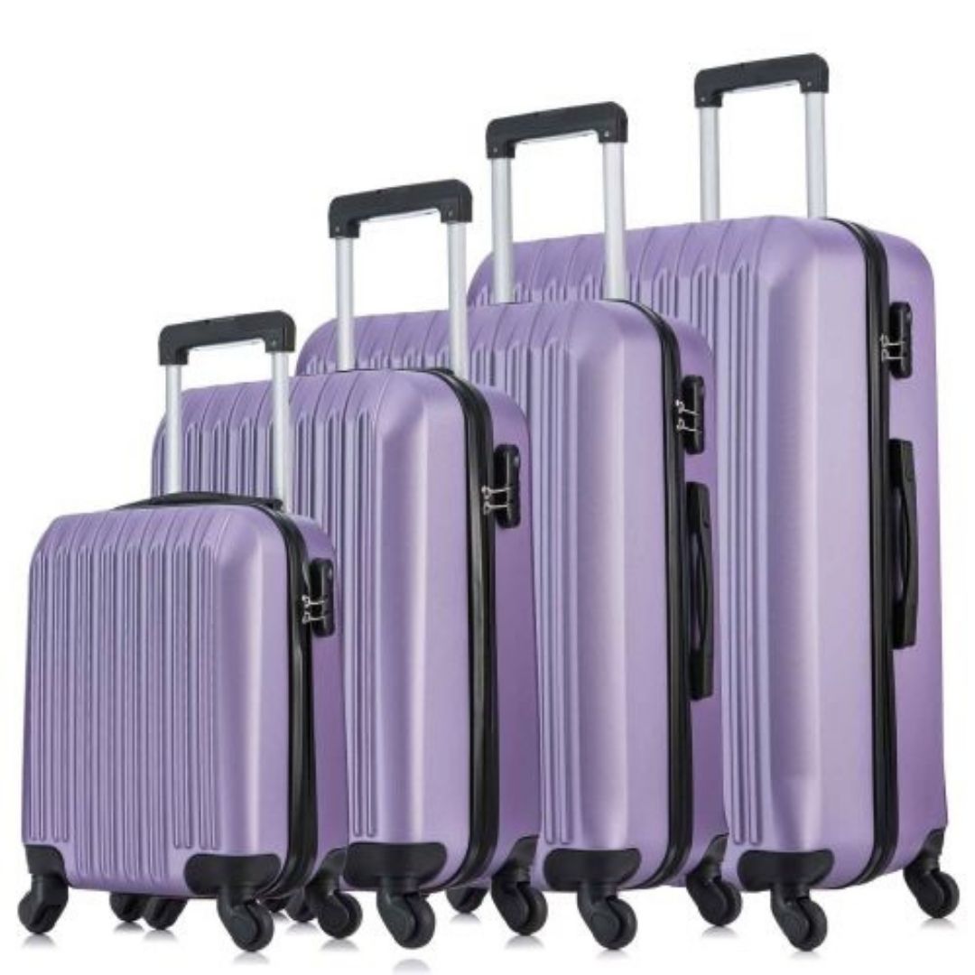 A four-piece purple hardshell luggage set with a vertical ribbed texture, arranged from smallest to largest.